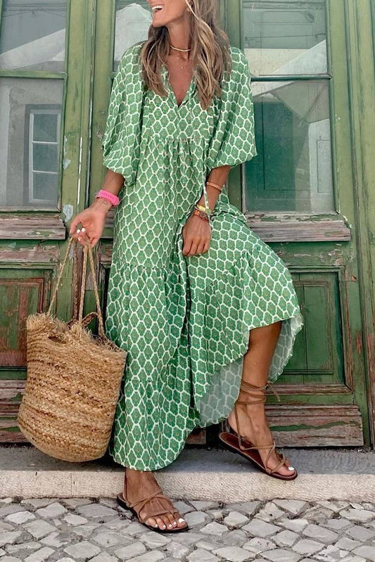 A woman in a Rosa Clothing Bohemian Floral Balloon Sleeves loose flare swing dress and brown sandals, holding a woven straw bag, stands before an old green wooden door.