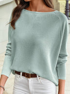 A person wearing the 1 the Woman Spring 2026 Solid Style Texture Jacquard Shift Top in light green, tucked into white pants with a brown belt, is standing outdoors.