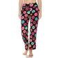 A person wears Leggings Depot's Buttery Soft Print Pajama Pants featuring a colorful donut pattern and elastic waistband, standing barefoot against a plain white background.