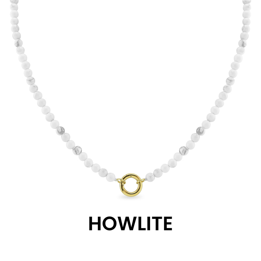 WJW Semi Precious Natural Stone Charm Keeper Necklace crafted with white howlite stones and finished with a circular 18K Gold PVD-coated clasp, elegantly displayed on a white background with the word "HOWLITE" below—a timeless accessory designed for enduring style.