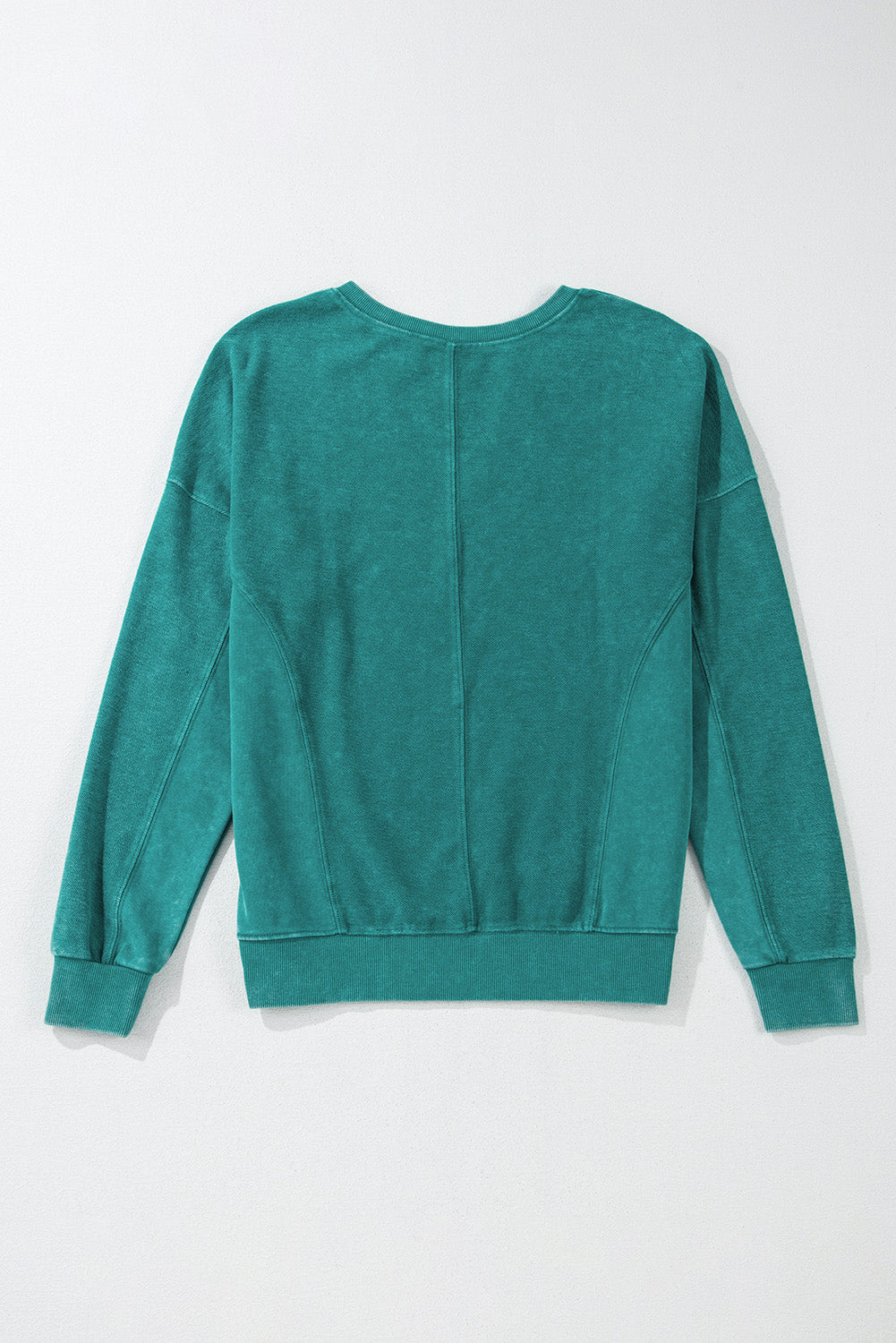 The Shewin Notched Neck Exposed Seam Drop Shoulder Sweatshirt in teal boasts a patchwork design on a light background. Crafted from high-quality fabric, it offers lasting comfort, making it your go-to choice repeatedly.