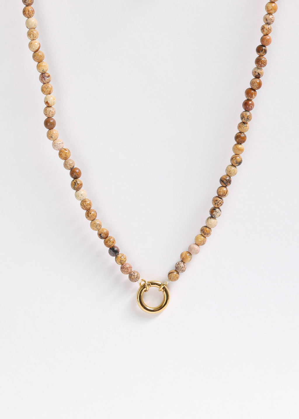Introducing the WJW Semi Precious Natural Stone Charm Keeper Necklace: this exquisite piece features round, brown semi-precious stones and is elegantly accentuated by a central gold circular clasp with a luxurious 18K Gold PVD Coated finish. Perfectly showcased against a plain white background, this sophisticated necklace highlights timeless charm and style.
