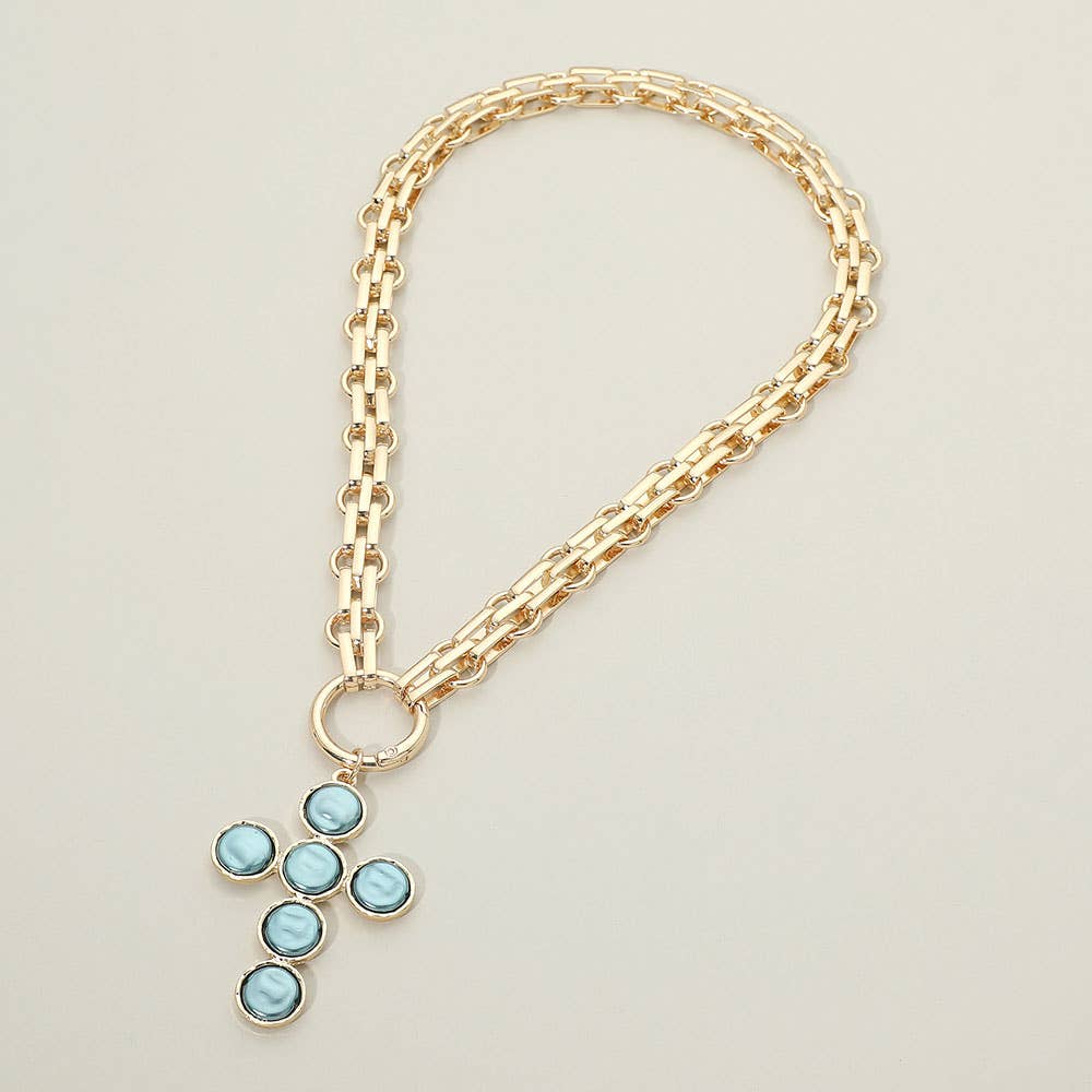 Sensibling Corp.’s Pearl Cross Charm Pendant Chunky Chain Statement Necklace is showcased on a light, neutral background. This gold chain necklace features a textured cross pendant adorned with six round blue gemstones.