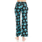 A person stands barefoot, shown from the back, in Leggings Depot Buttery Soft Print Pajama Pants—loose black pants with large blue paw prints and an elastic waistband for comfort, set against a white background.