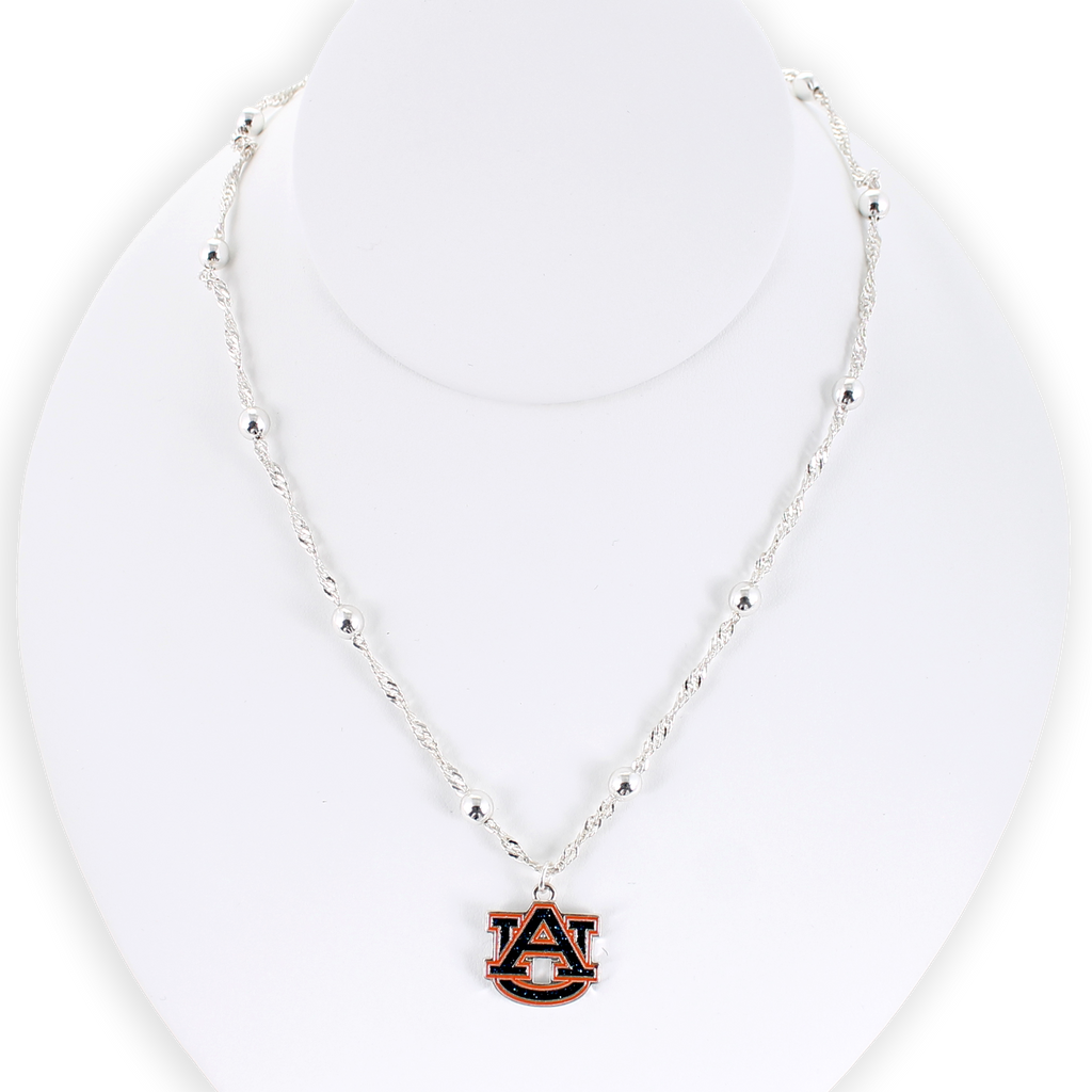 The Seasons Jewelry Auburn Glitter Enamel Logo Necklace features a silver beaded chain and a sparkling AU logo charm pendant, beautifully presented on a white display bust.