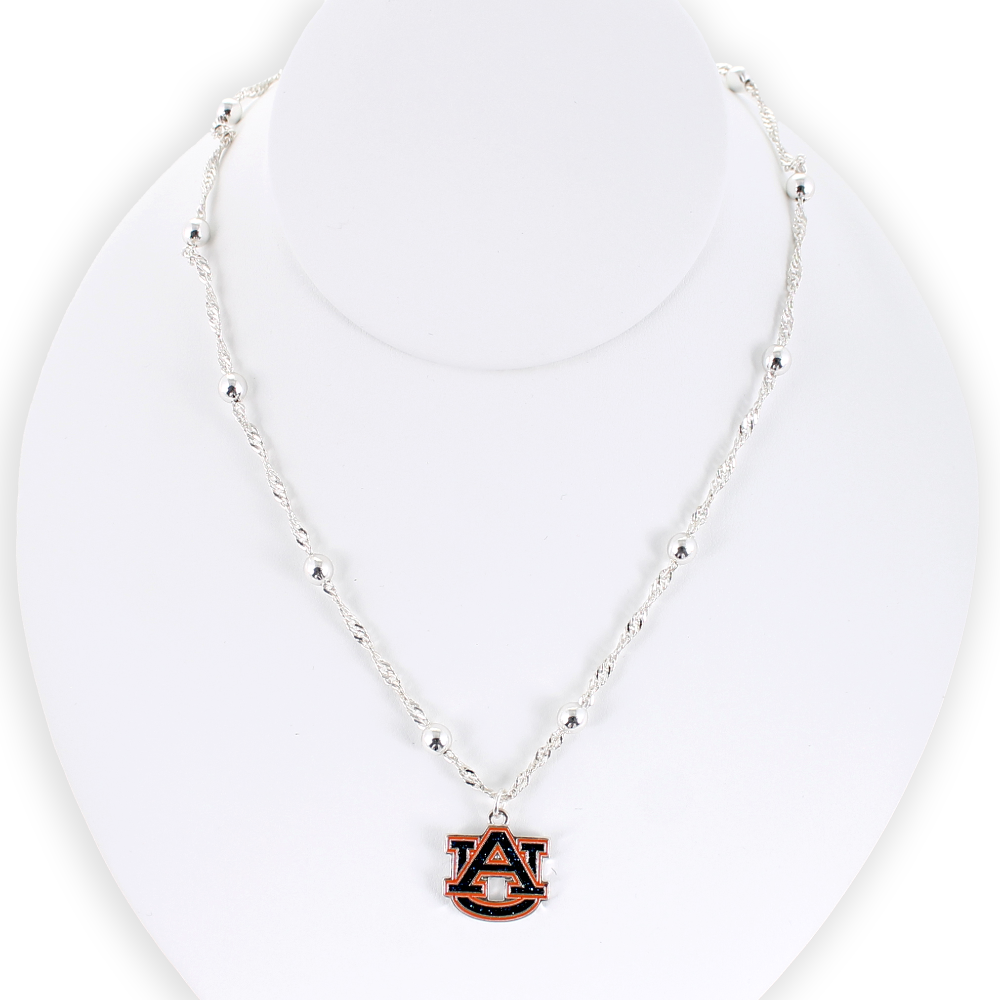 The Seasons Jewelry Auburn Glitter Enamel Logo Necklace features a silver beaded chain and a sparkling AU logo charm pendant, beautifully presented on a white display bust.