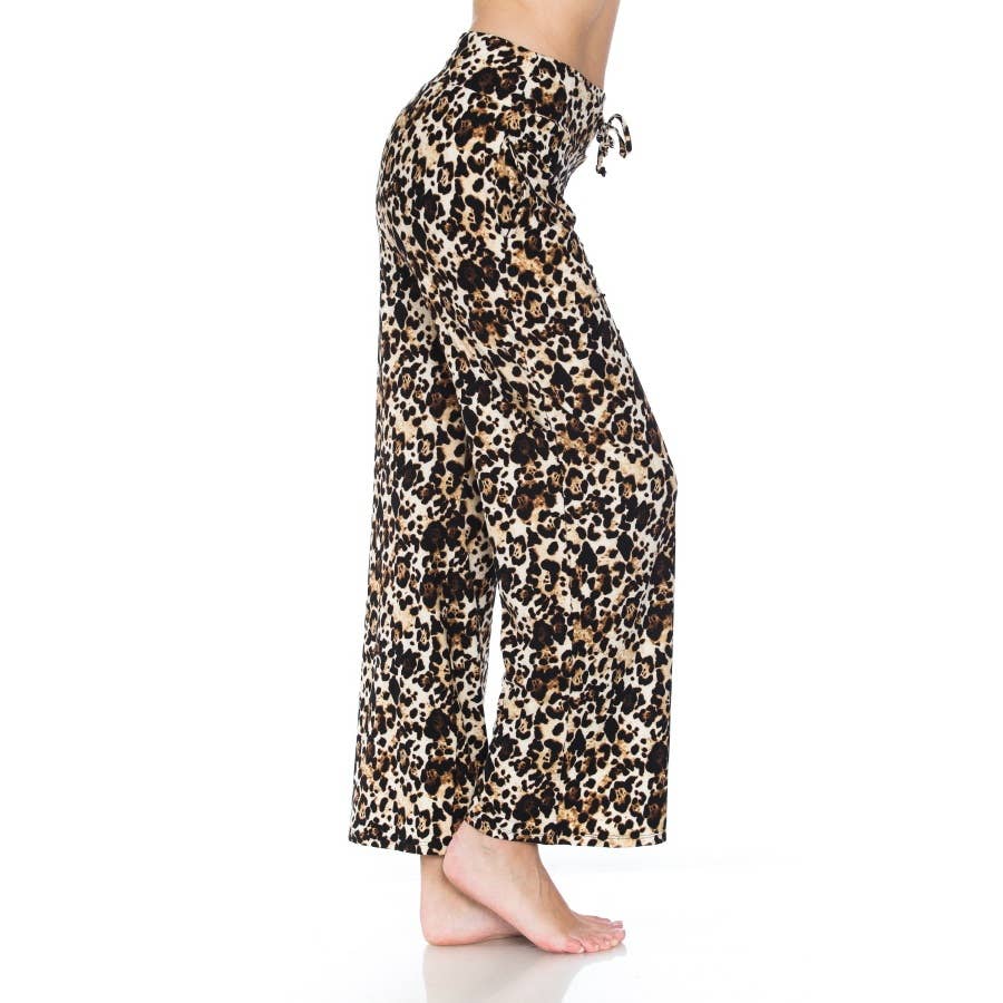 A person stands barefoot sideways on a white background wearing Leggings Depot Buttery Soft Print Pajama Pants, featuring a loose fit, leopard print design, and elastic waistband.