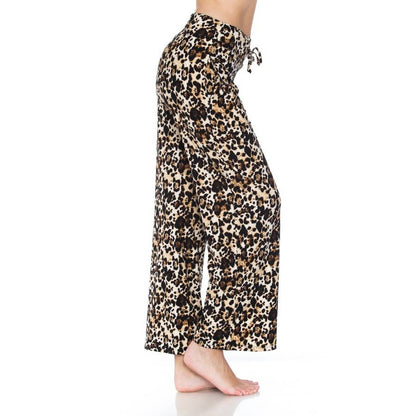 A person stands barefoot sideways on a white background wearing Leggings Depot Buttery Soft Print Pajama Pants, featuring a loose fit, leopard print design, and elastic waistband.