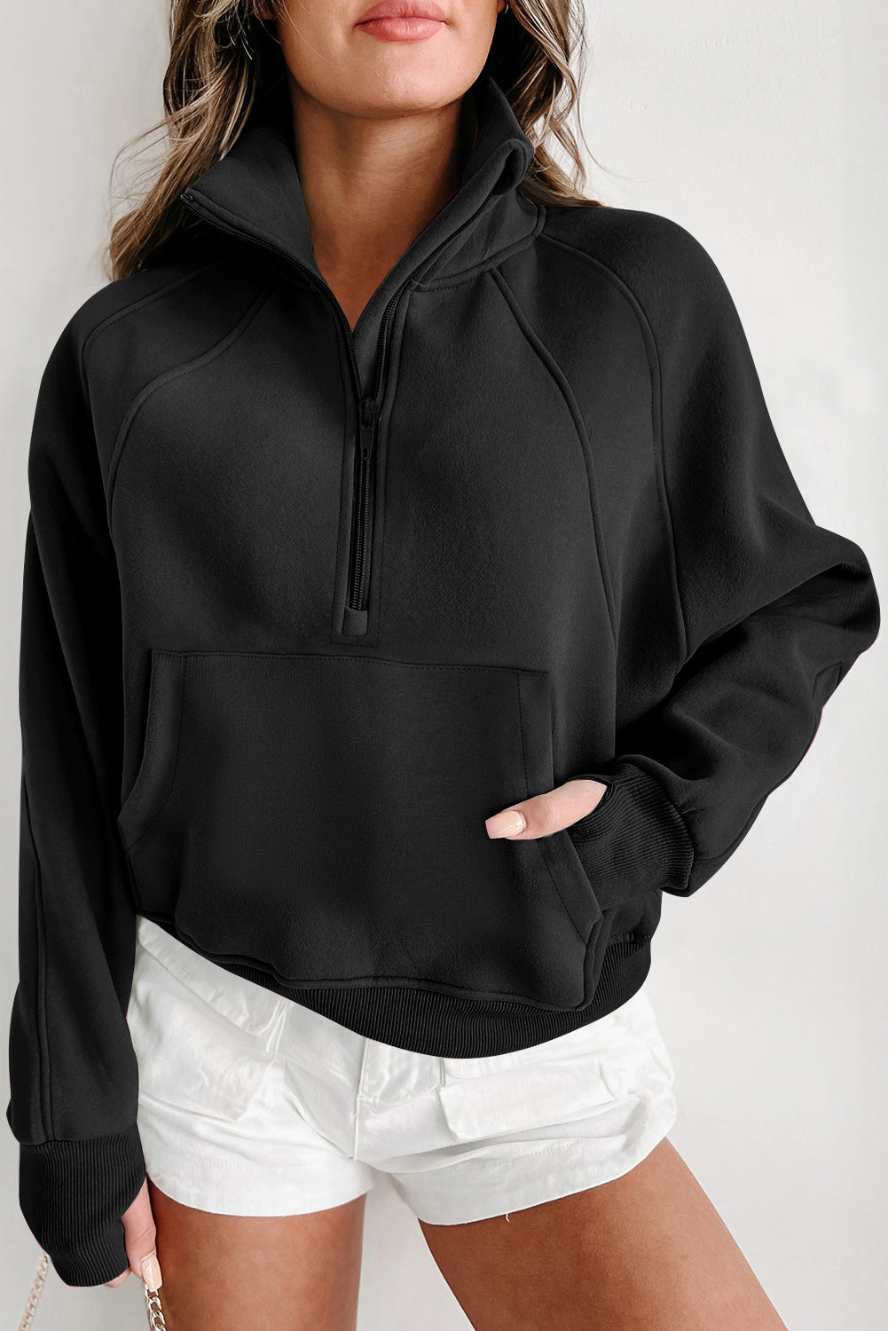 A person wearing a Shewin gray zip-up stand collar ribbed thumbhole sleeve sweatshirt and white shorts is standing against a plain background.