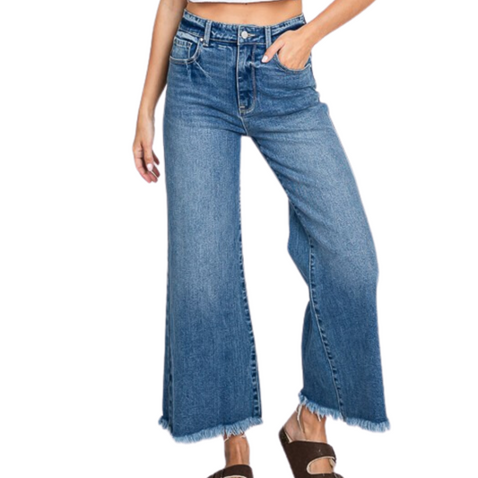 A woman sporting Fashiongo High Rise Comfort Wide Crop Jeans with a frayed hem.