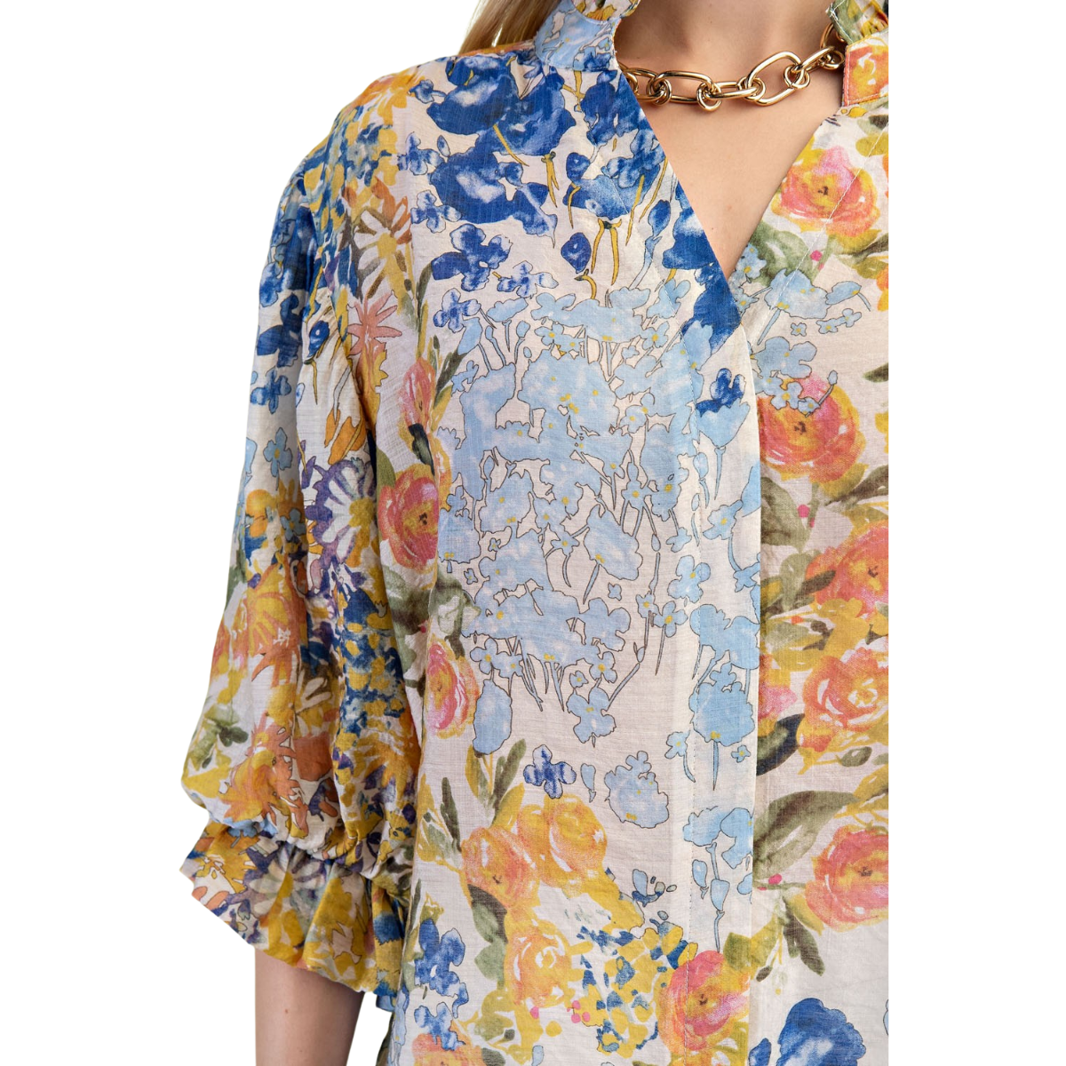 Close-up of a person wearing the FASHION GO Floral Print Button Down Top with blue, yellow, and pink flowers and 3/4 sleeves, paired with a gold chain necklace. Only the upper torso and part of one arm are visible.