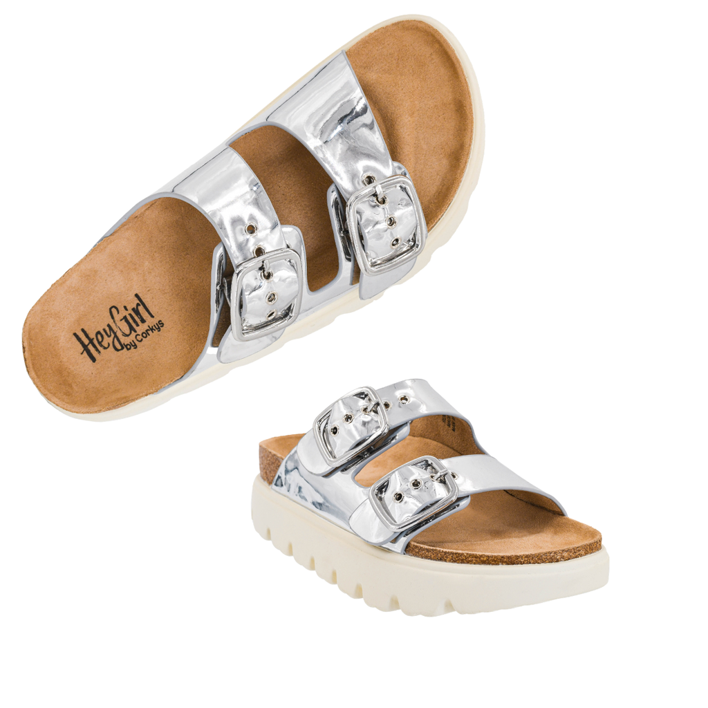 The Rumor Has It Platform Slide by Flipflops & Whatnots features silver metallic sandals with two wide adjustable buckle straps, a cork footbed, and a white ridged outsole.