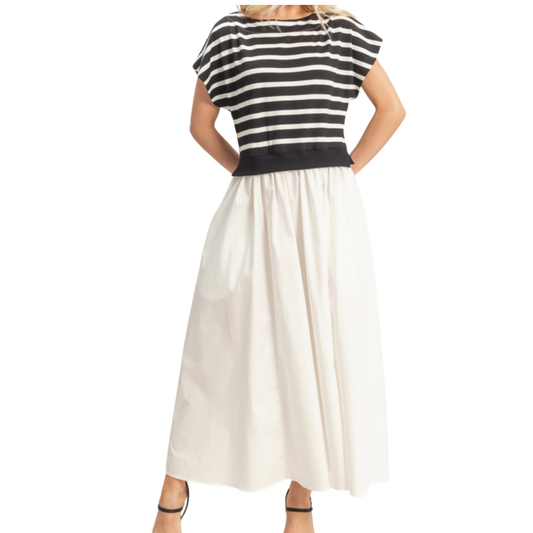 A person in the Fashiongo Striped Short Sleeve Midi Dress Black, viewed from the back, creates an elegant silhouette with its black and white stripes and ribbed waist.
