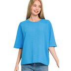 Woman wearing a Zenana Double Knit Short Sleeve Top in blue and denim shorts, standing against a white background.
