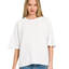 A woman wears the Zenana Double Knit Short Sleeve Top in white with blue jeans, standing facing forward against a plain white background.