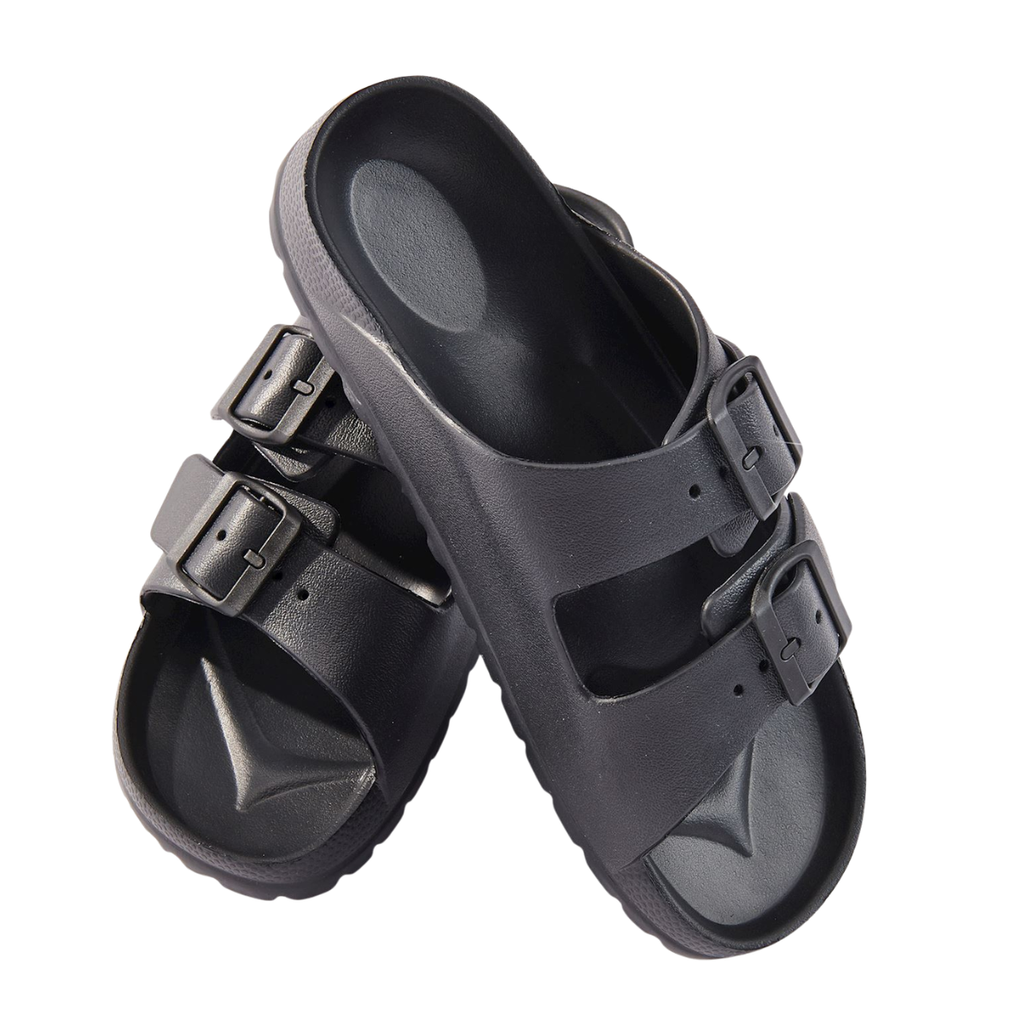 The Essential Slip-On Slides by Gift Craft are black waterproof slip-ons with two adjustable buckle straps, stacked together against a white background.