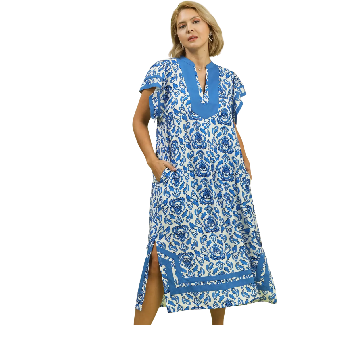 A woman models the Umgee Abby Blue Print Midi Dress, featuring blue and white floral prints, short sleeves, V-neckline, side pockets, and slits, set against a white background.