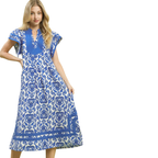 A woman poses against a white background in the Abby Blue Print Midi Dress by Umgee, featuring blue floral patterns and blue trim, with one hand on her hip.