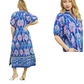 A woman models the Umgee Boho Border Print Midi Dress, featuring a blue floral pattern, short sleeves, slit detail, and shown from the back and in a close-up front view.
