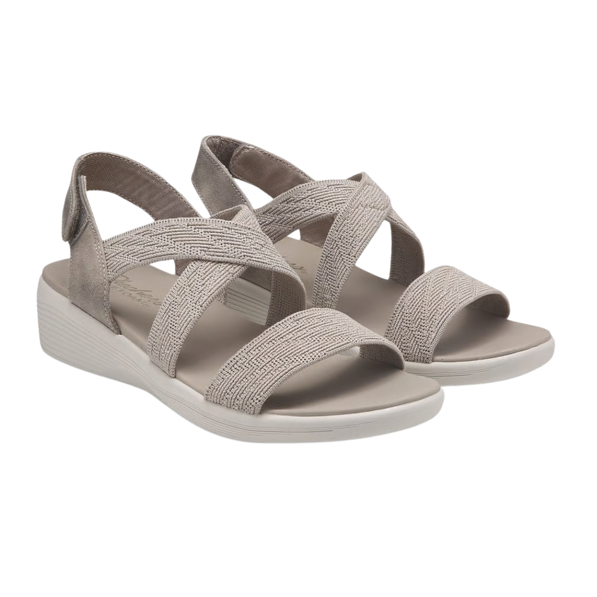 A pair of SKECHERS Arya Very Midful Low Wedge Heel Sandals in light beige, featuring open toes and crisscross elastic straps, is displayed on a white background.