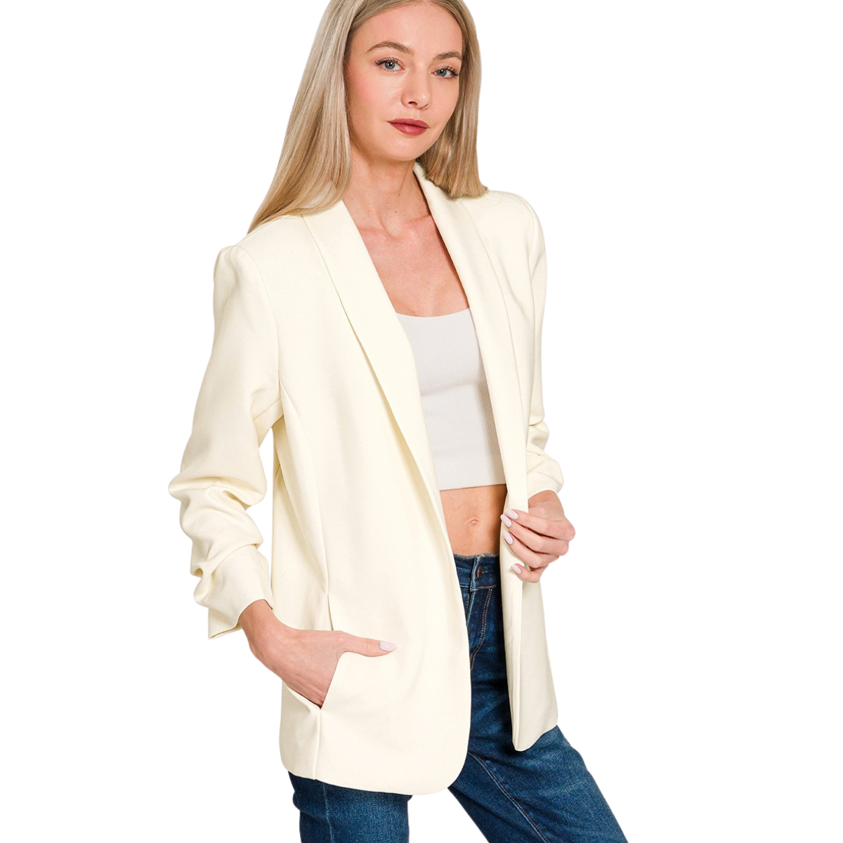 A woman models the Zenana Ruched Sleeve Open Front Blazer in cream over a white crop top and blue jeans, standing with one hand in her pocket against a white background. Main image
