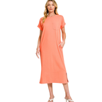 A woman models the Zenana Round Neck Short Sleeve Midi T-Shirt Dress, featuring a loose fit, chest pocket, and side slit, against a white background.