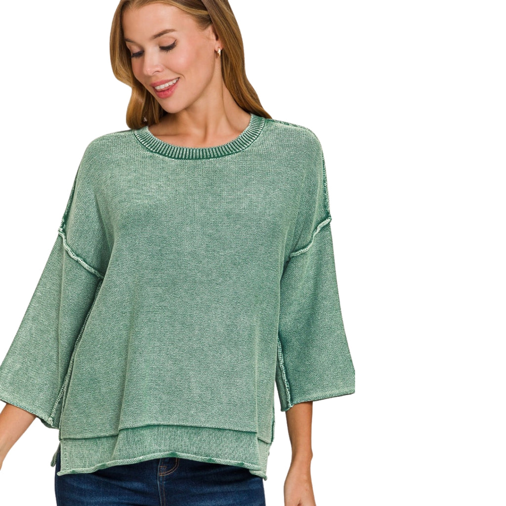 A woman wearing a green Women’s Washed Cotton Boxy Sweater with 3/4 Sleeves, featuring a boxy silhouette and a stepped hem.