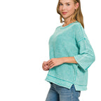 Woman wearing a teal Women’s Washed Cotton Boxy Sweater with 3/4 Sleeves, featuring a boxy-fit, three-quarter length sleeves, and a stepped hem.