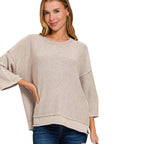 A woman wearing a FASHION GO Women’s Washed Cotton Boxy Sweater in beige, featuring a boxy silhouette, three-quarter length sleeves, and a stepped hem.