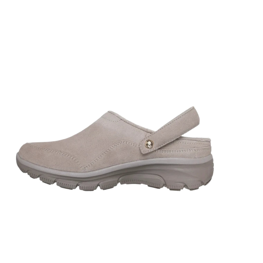 Light beige SKECHERS Easy Going Distinctive Charm Relaxed Fit suede clog with a back strap and textured rubber sole, featuring Air-Cooled Memory Foam for lasting comfort, shown from the side against a white background.