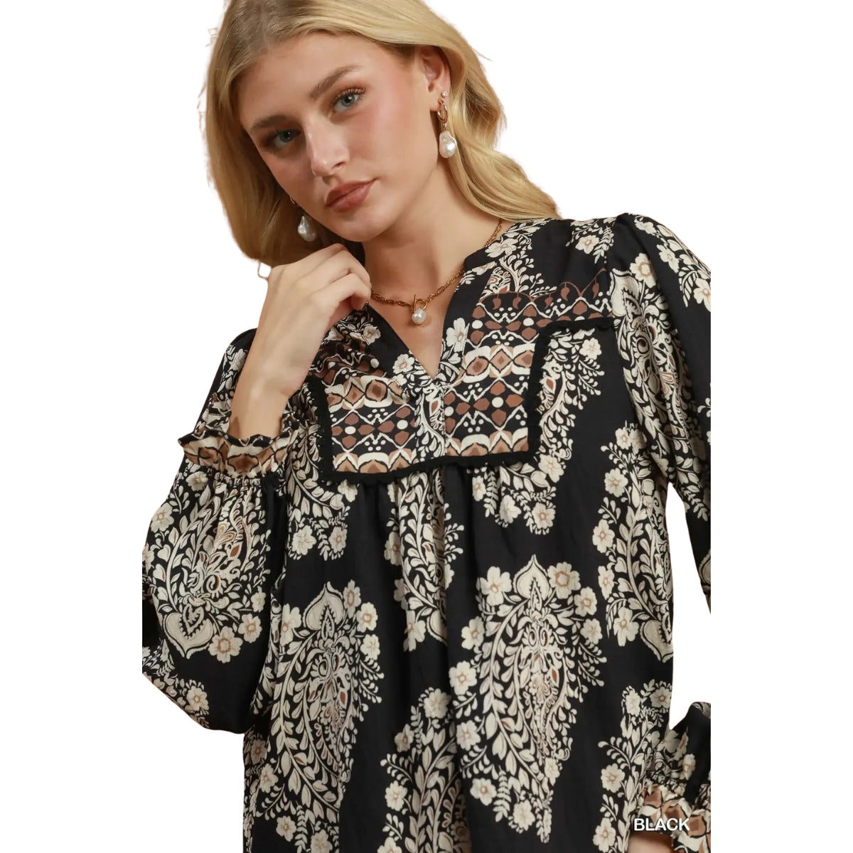 Woman wearing the Boho Paisley Blouse by Umgee, featuring black balloon sleeves with floral and geometric patterns, against a white background.