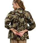 Back view of an Umgee Paisley Print Puff Sleeve blouse featuring a boho paisley print, high ruffled collar, long sleeves with gathered cuffs, and a brown multi-colored pattern.