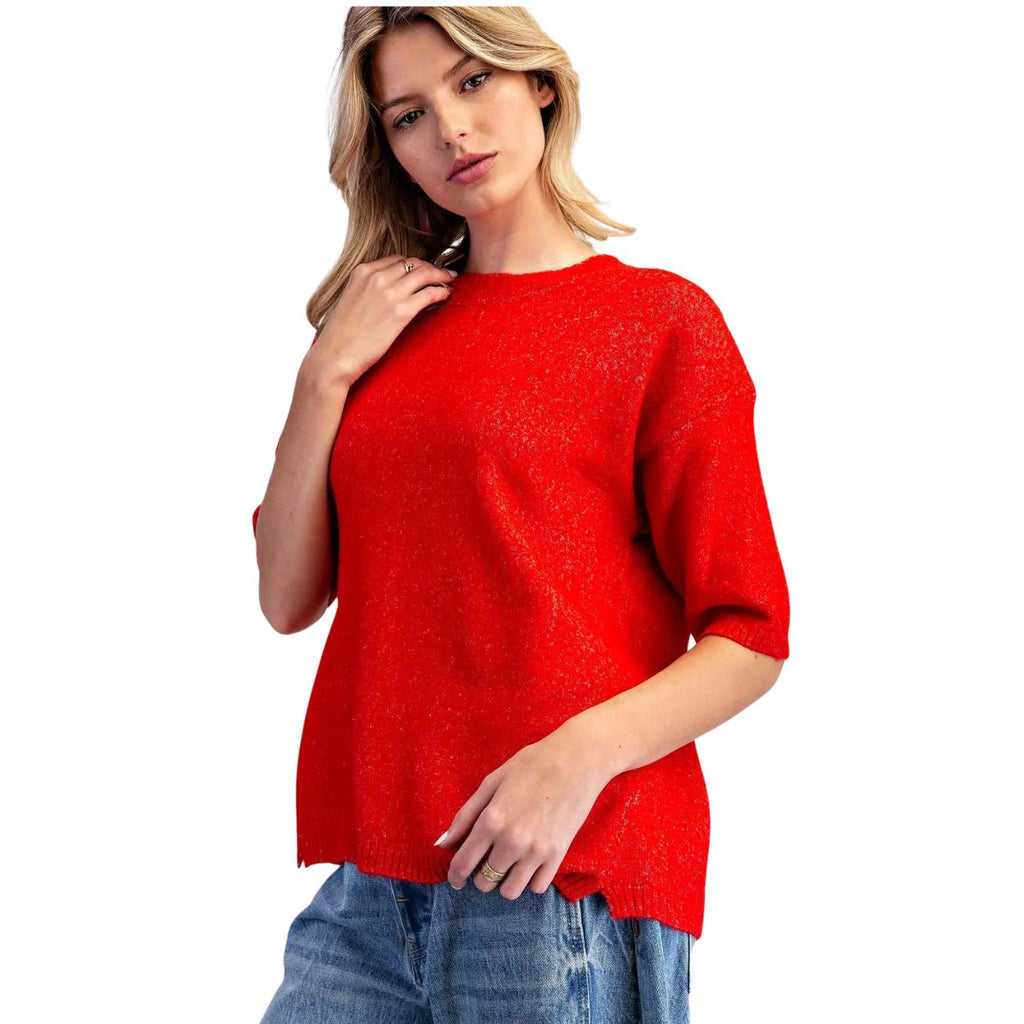 A woman wears an eesome Marled Knit Cherry Red Sweater, a cherry red, short-sleeved marled knit sweater.