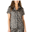 A woman wears the Hello Mello Bow So Lovely Satin Pajama Top by DM MERCHANDISING INC, a silky, short-sleeved, button-up sleep top with a chic brown and black leopard print pattern.