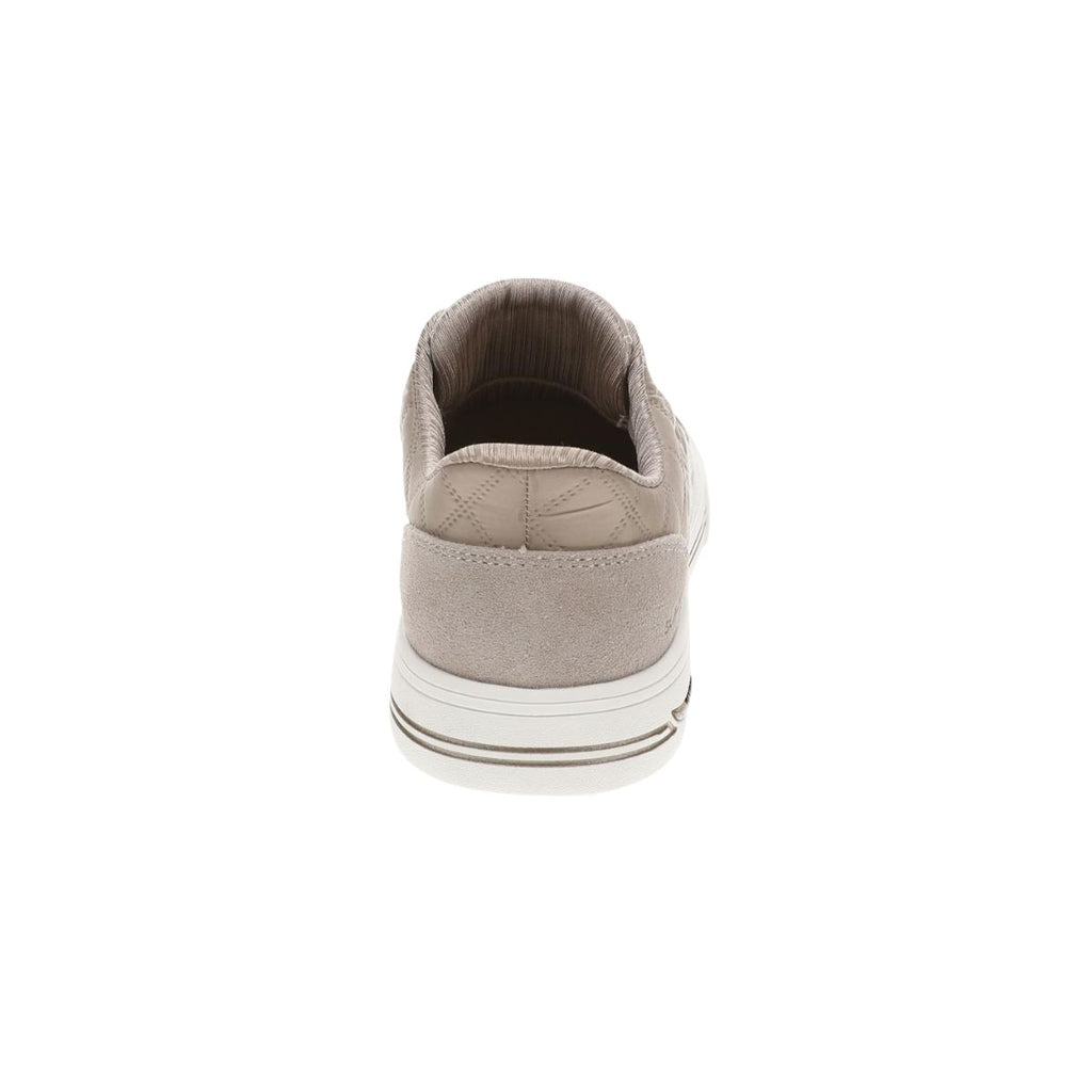 A rear view of the SKECHERS USA INC Arch Fit Cuddle Steps Slip Ins sneaker in beige highlights its heel, white sole accented with a brown stripe, and quilted upper pattern. Featuring Arch Fit support, this style ensures enhanced comfort for everyday wear.