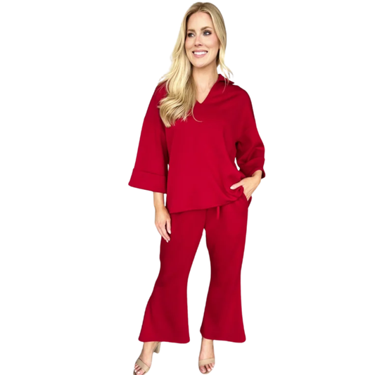 A woman wears the Carole Christian Modal Scuba Fabric Set in red, featuring a loose fit with wide sleeves and matching pants—ideal for effortless day-to-night style.