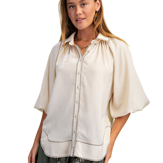A woman wears the FASHION GO Satin Balloon Sleeve Button Down Blouse with wavy hem and stitch detail, standing against a white background.