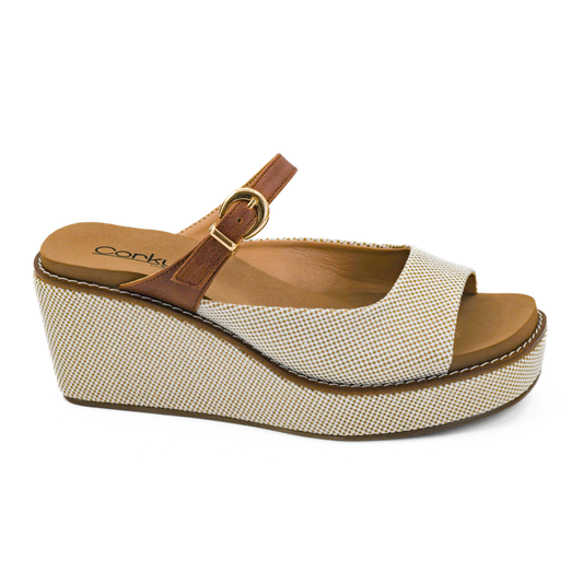 The Treat Yourself Peep Toe Wedge by CORKY'S FOOTWEAR is a beige slip-on sandal with a textured platform, open toe, brown ankle strap with gold buckle, and cushioned comfort for all-day wear.