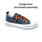 A Western-inspired sneaker from VERY G, the Aman Navy Tooled Sneakers feature a dark navy upper with intricate tooled floral detailing, a crisp white sole and toe, and eye-catching rhinestone shoelaces. Text above reads: “Rhinestone shoelaces purchased separately.”.