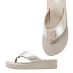 The Yellow Box Leyla Wedge Flip Flop Sandal features metallic silver textured woven straps, a beige sole, and a subtle floral logo on the cushioned footbed for comfortable all-day wear.