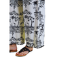 A person models the FASHION GO Toile Print 2 piece Set, featuring relaxed fit pants with a black and white tropical design and black sandals, against a white background.