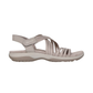 The SKECHERS Reggae Slim Sunnyside sandal in beige features elastic straps, an open toe, adjustable Velcro ankle strap, and cushioned footbed—shown in side profile and ideal for comfortable summer wear.