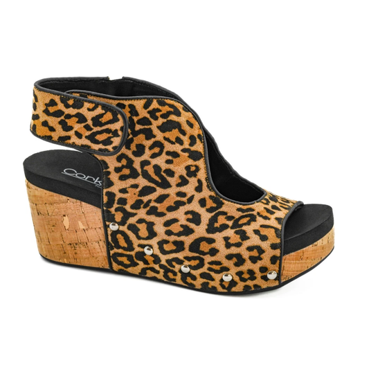The Frisky Leopard Wedge Sandal by CORKY’S FOOTWEAR INC features a cork platform, open toe, ankle strap, side metallic studs, and a cushioned footbed for all-day comfort.