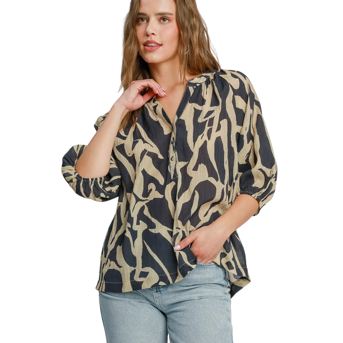A woman wears an Umgee Two Tone Abstract Print Blouse with rolled-up sleeves and blue jeans, standing against a white background.