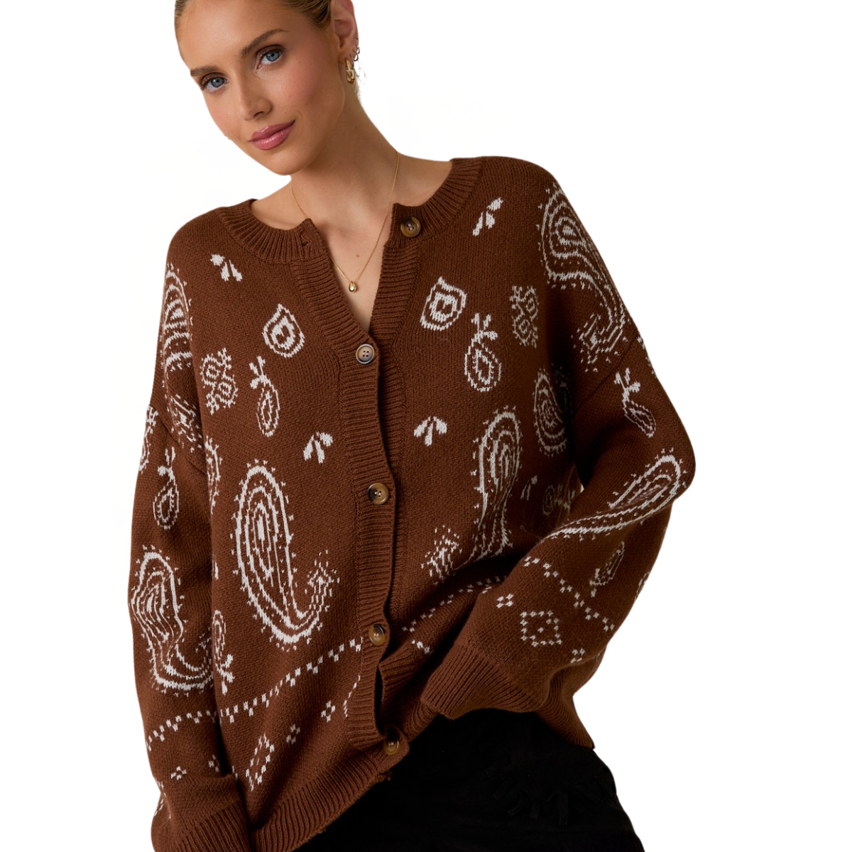 A woman wears the FASHION GO Brown and White Paisley Pattern Cardigan, featuring cozy knit fabric with paisley and geometric designs, buttoned up against a plain white background.