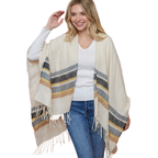 A woman stands and smiles, wearing the FASHION GO Striped Wrap with cream, gray, and mustard stripes and fringe, draped over a white ribbed sweater and blue jeans.