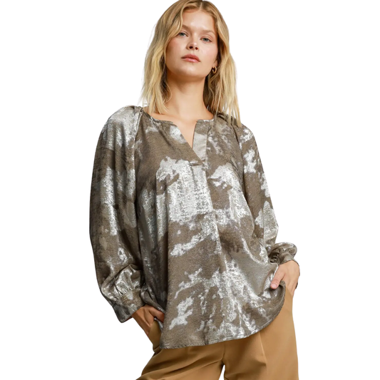 A woman models the Umgee Metallic V-notched Collar Blouse with bubble sleeves and beige pants, standing against a white background.