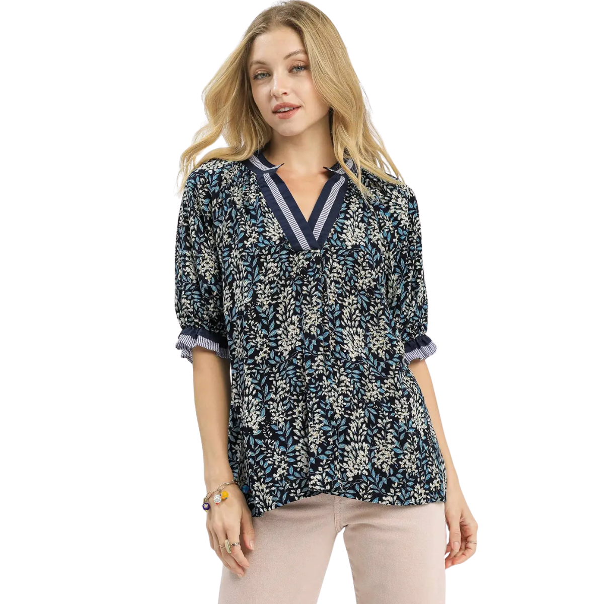 A woman wearing the Umgee Spring Burst Top in Navy Floral with half sleeves and light-colored pants stands against a white background.