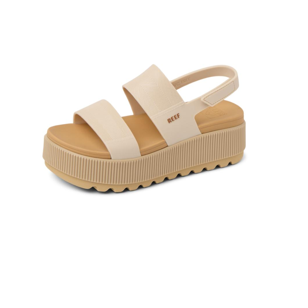 The REEF Water Vista Higher is a beige platform wedge sandal with two wide straps, a slingback heel strap, textured sole, cushioned footbed, and REEF logo on the side for stylish comfort.