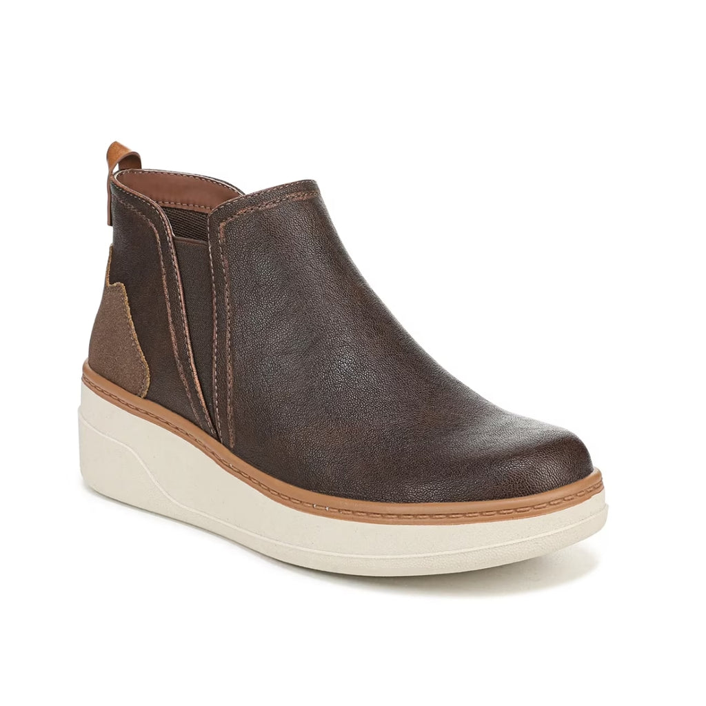 Introducing the Charming Wedge Sneaker Bootie by CALERES INC—a brown, Chelsea-inspired slip-on ankle boot featuring a white platform sole, side elastic panels, a brown back pull tab, and subtle stitching details. This modern sneaker bootie delivers everyday style with a chic wedge silhouette.